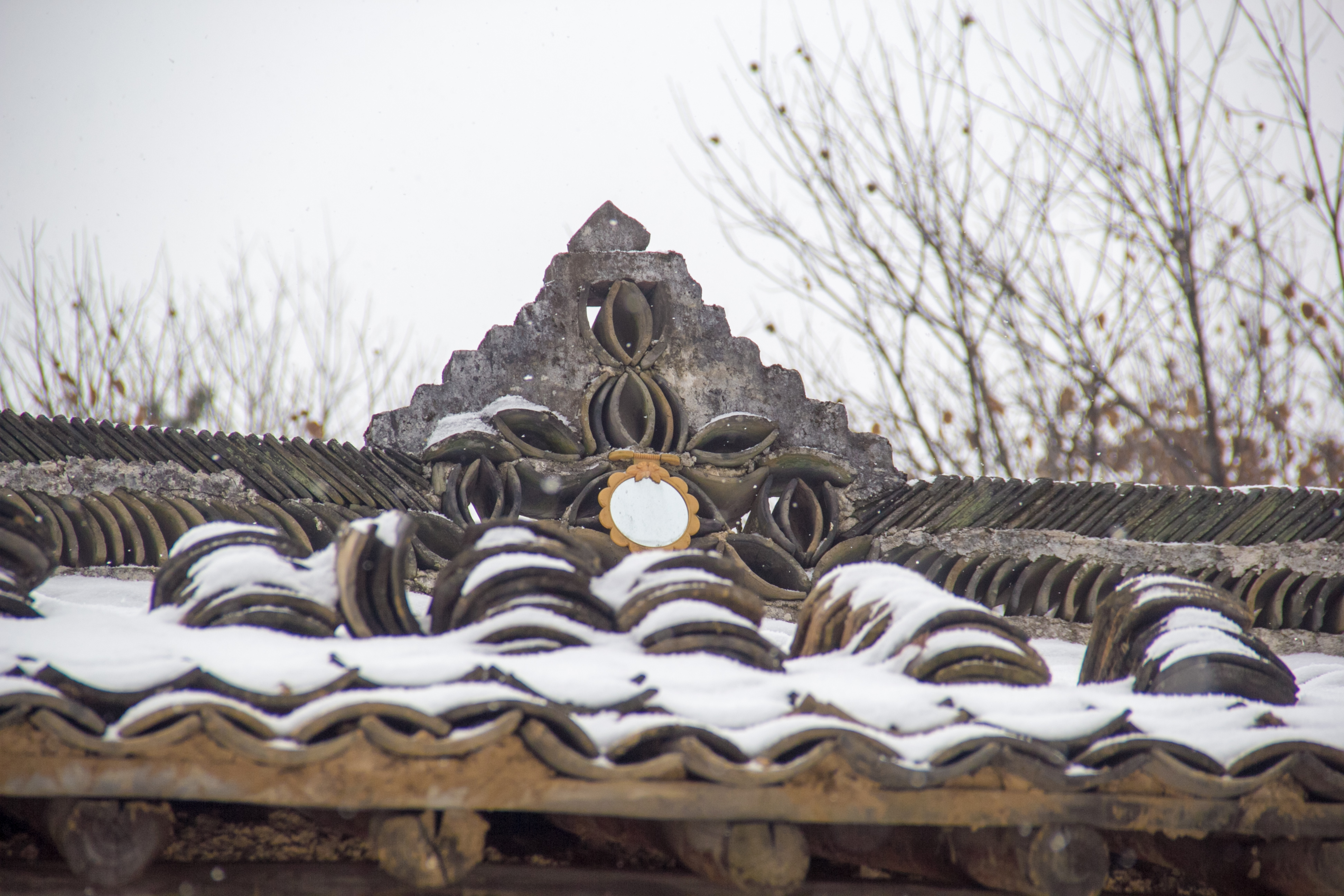 屋脊上的造型非常简单,类似一座山的模样,中间是用瓦片构成的花瓣样式