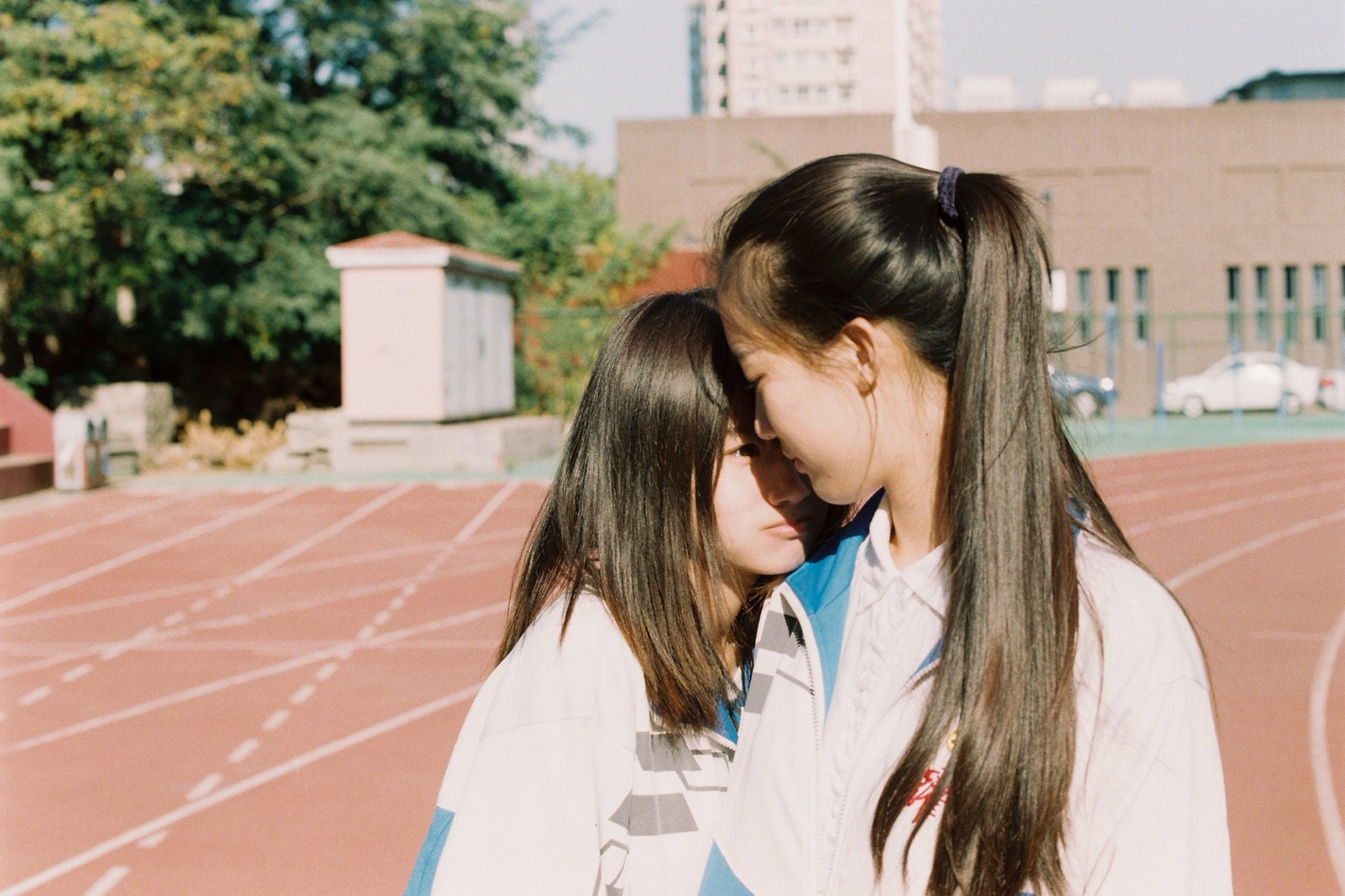 阳光里的校园操场,女同学靠肩,害羞的感觉