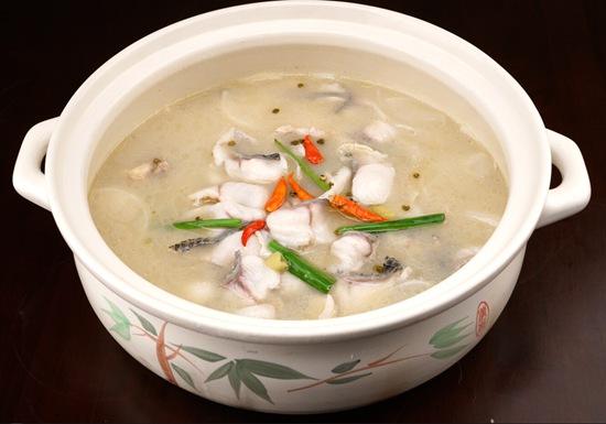 一块雪白的鱼肉泡在汤里,汤中的鱼肉上还摆放着一朵素黄的秋菊