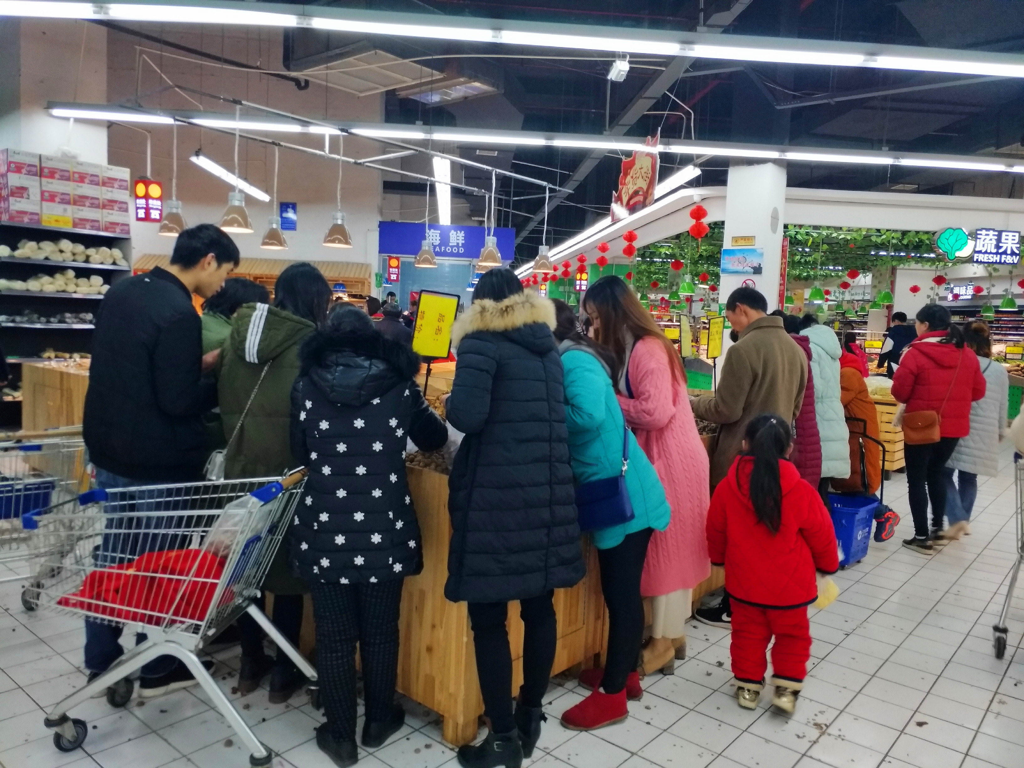 大年三十超市下午4点结束营业,市民趁最后的时间来抢购蔬菜坚果等