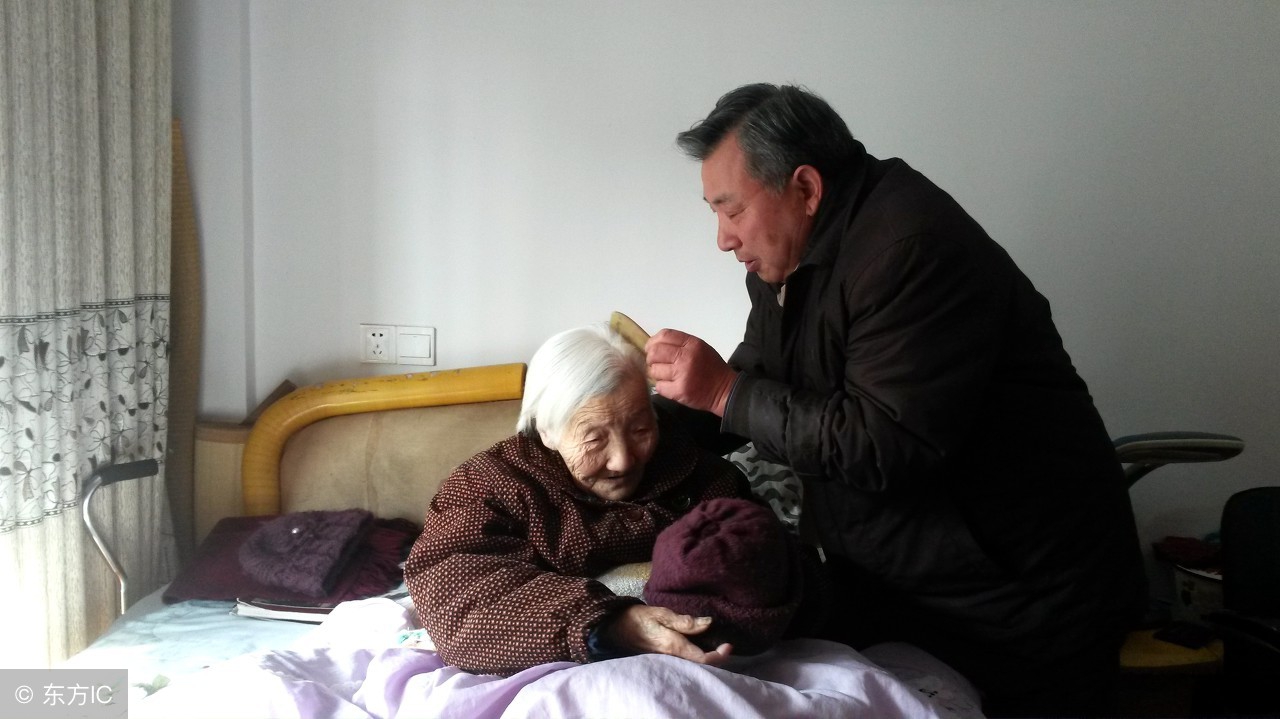 广西南宁市,孝子李军在医院的病床前准备给母亲喂食晚餐.