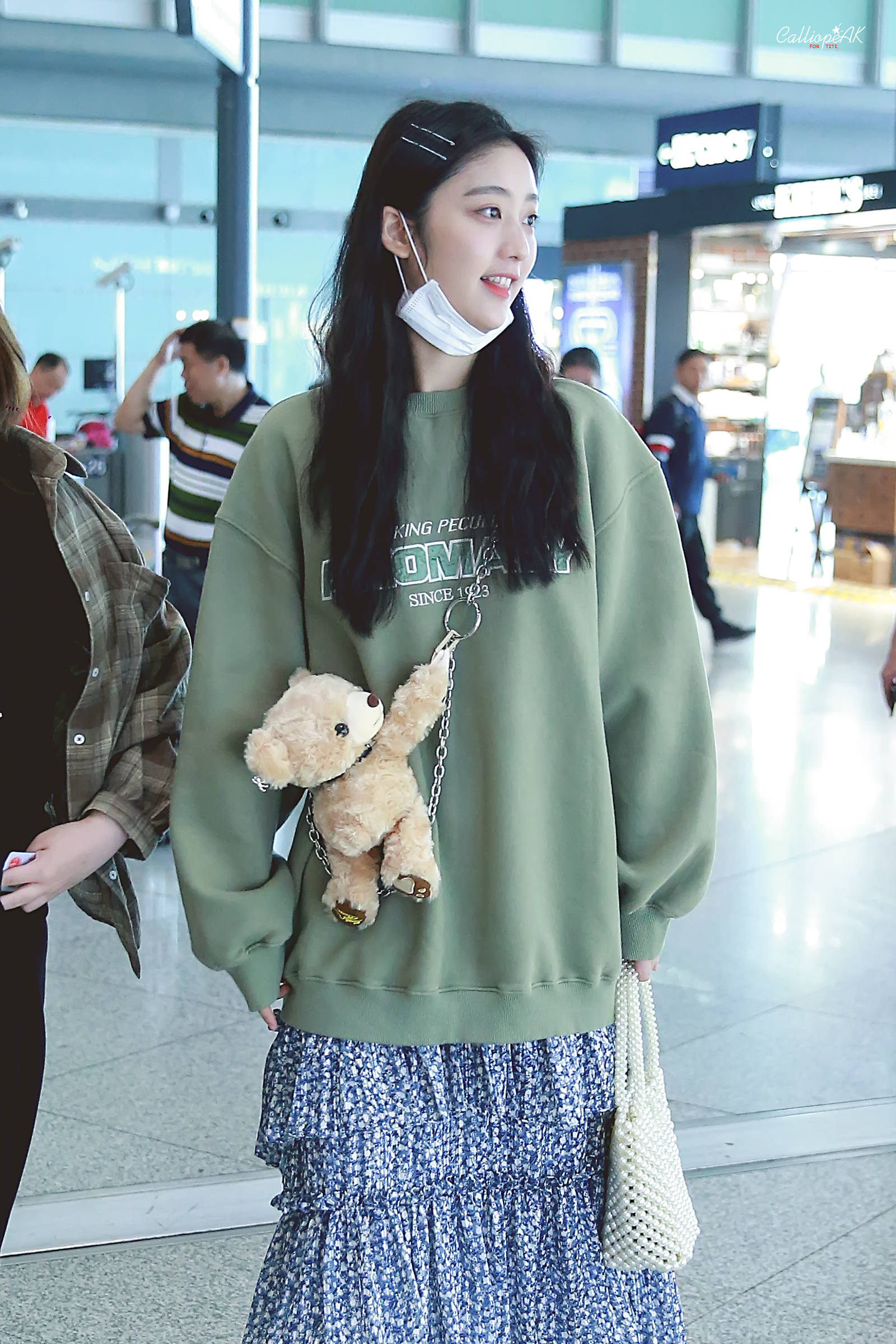 戚砚笛穿军绿色卫衣搭配蓝色碎花裙现身机场,皮肤白皙,面带微笑.