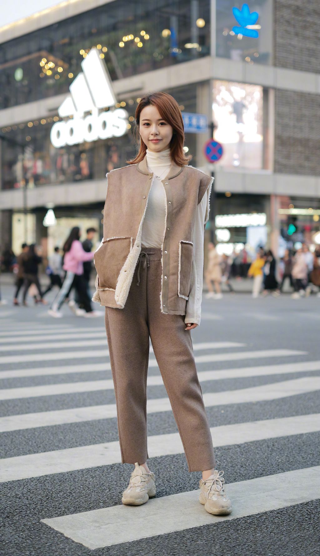 街拍:图中美女身穿卫衣搭配马甲,下身一条运动裤,颇显运动风.