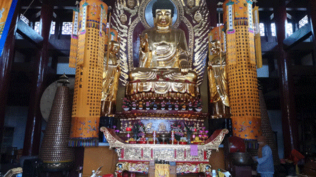 大殿内佛祖威严,正有僧人在敲木鱼念经,虔诚且庄重.