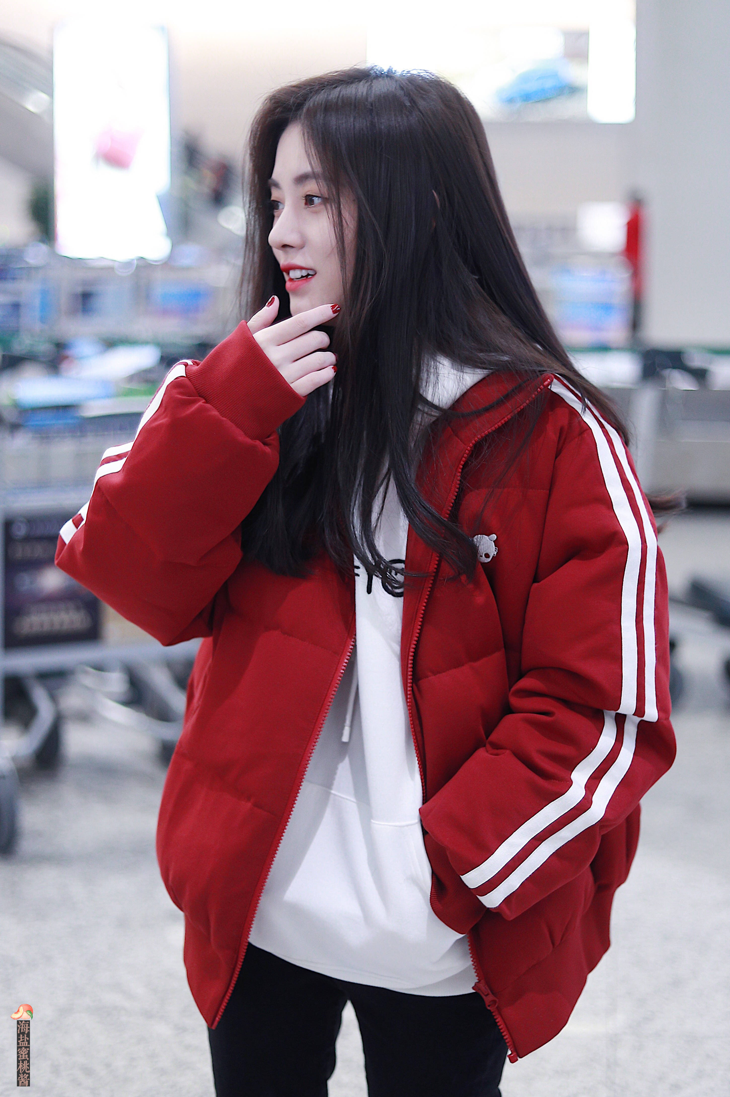 鞠婧祎穿红色羽绒服内搭白色卫衣现身机场,皮肤白皙,笑容甜美.