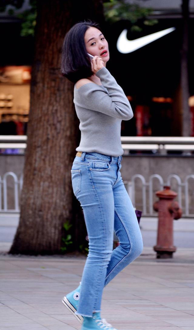 气质干练的短发美女,穿灰色线衣搭配休闲牛仔裤,上身时尚大方有气质