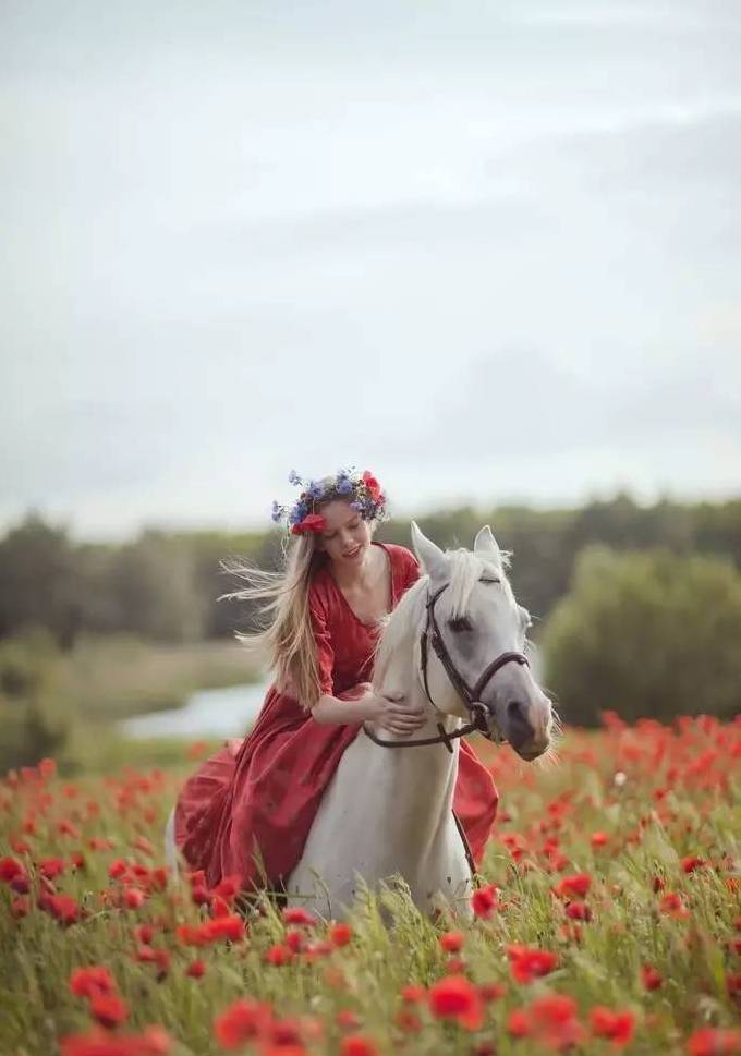 红裙美女骑马置身罂粟花丛