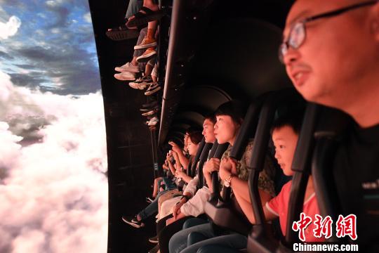 姬东 摄 8月18日,观众在广州融创乐园体验"全景球幕飞行影院—5d