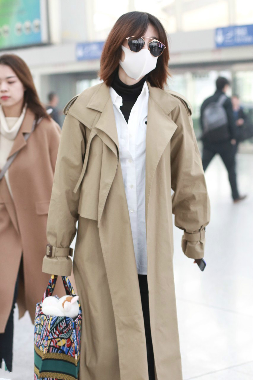 王丽坤穿卡其色长款风衣现身机场,戴墨镜和白色口罩遮捂好严实.