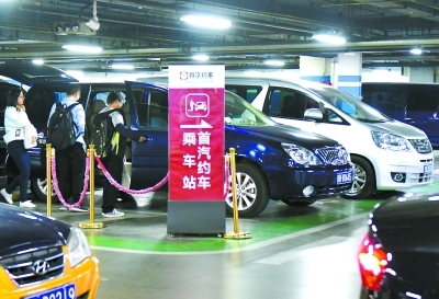 昨天,在北京南站地下停車場首汽約車專用停車區,到站旅客正在依序乘坐