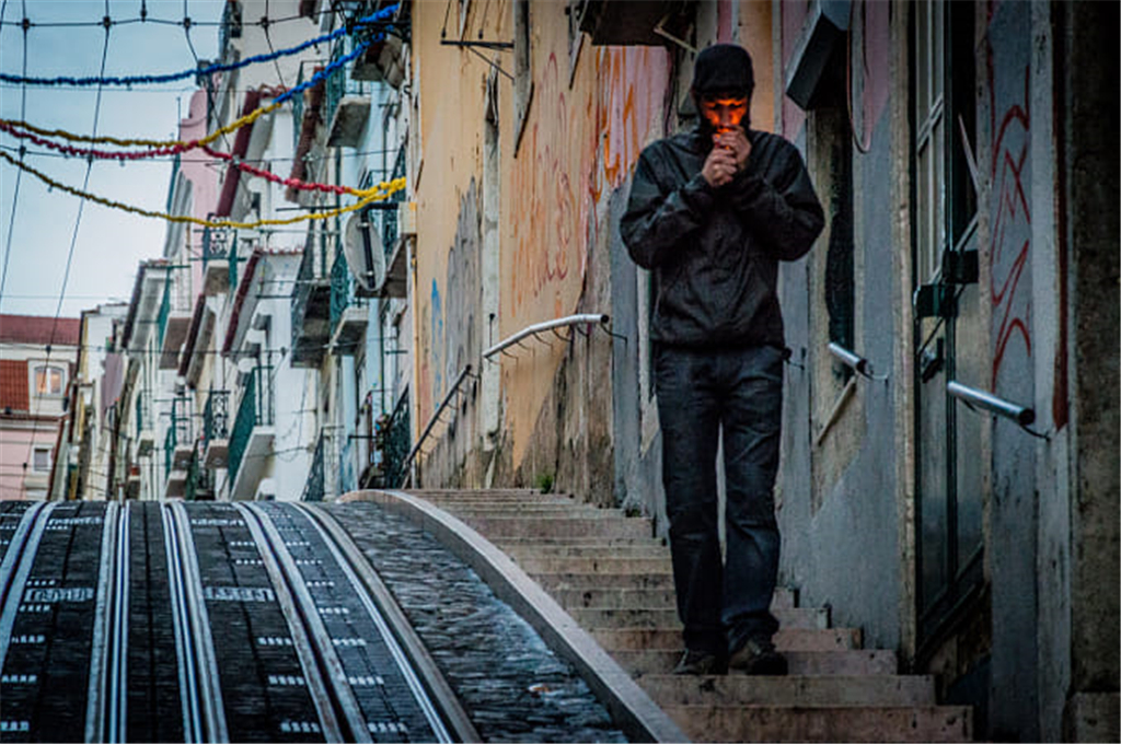 小巷里正在打火抽烟的男人.