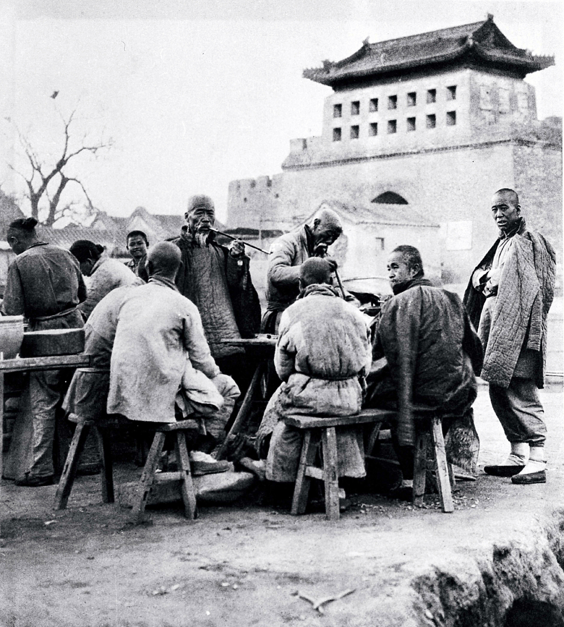 晚清时期的真实老照片,城门外的一群农民,他们围着一张桌子,正在闲聊.