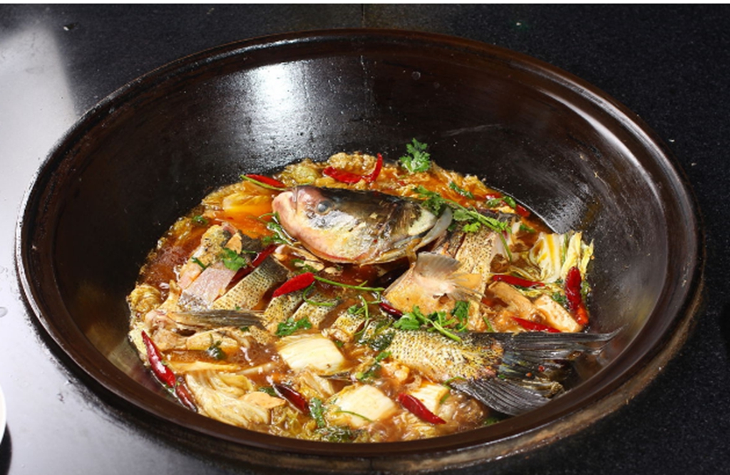 铁锅炖鱼,用的是一口大铁锅,烧的是柴火.