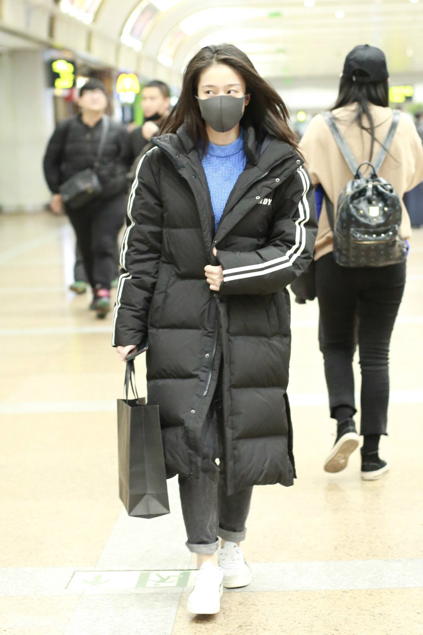 张雪迎戴黑色口罩穿黑色长款羽绒服现身机场,穿着非常保暖又时尚