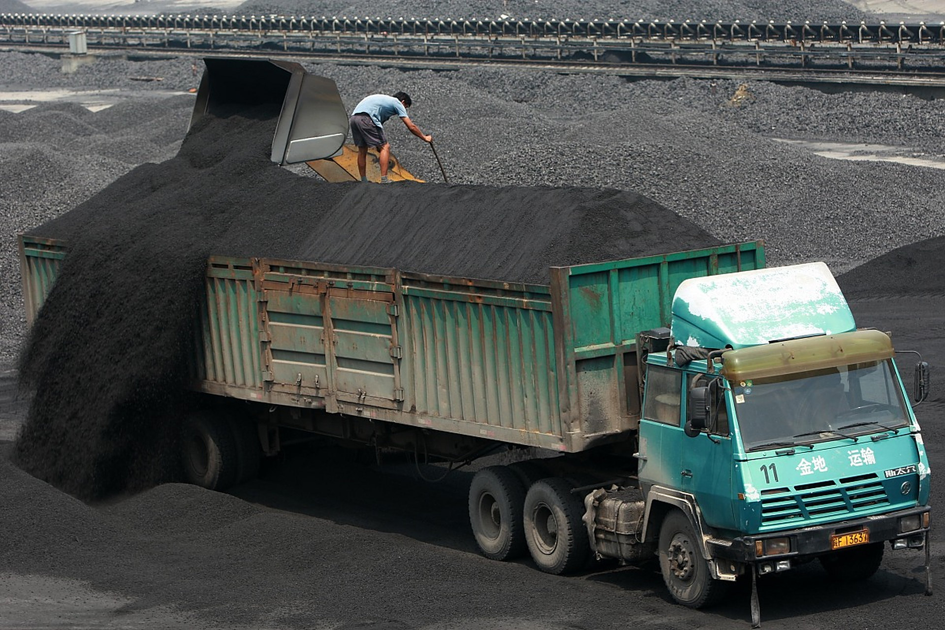 父亲弯下腰,拉着重型运煤车,一步步艰难地走着