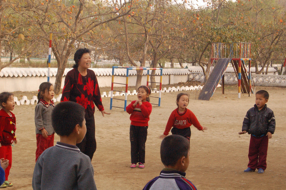 图为朝鲜新义州的一家幼儿园,幼儿园老师正带着小孩游戏.