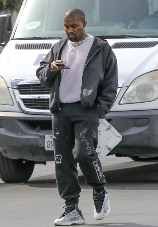 "侃爷"坎耶·维斯特穿潮鞋出街,一路看手机成低头族