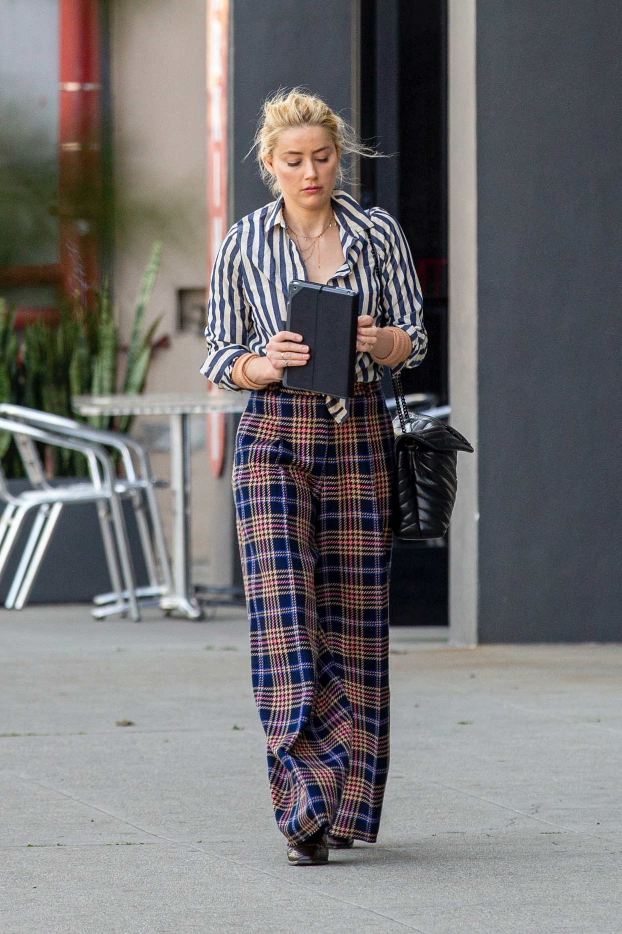 艾梅柏·希尔德穿条纹上衣搭配格子纹阔腿裤,略微有些憔悴