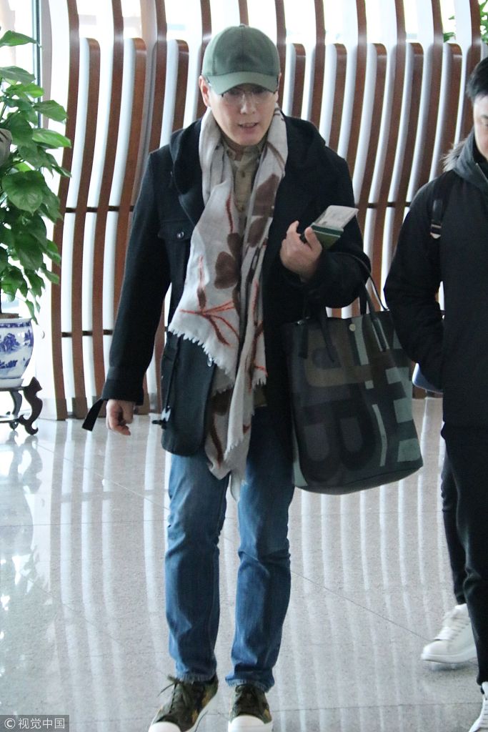 张信哲着装简便现身机场   戴鸭舌帽裹围巾显绅士风范