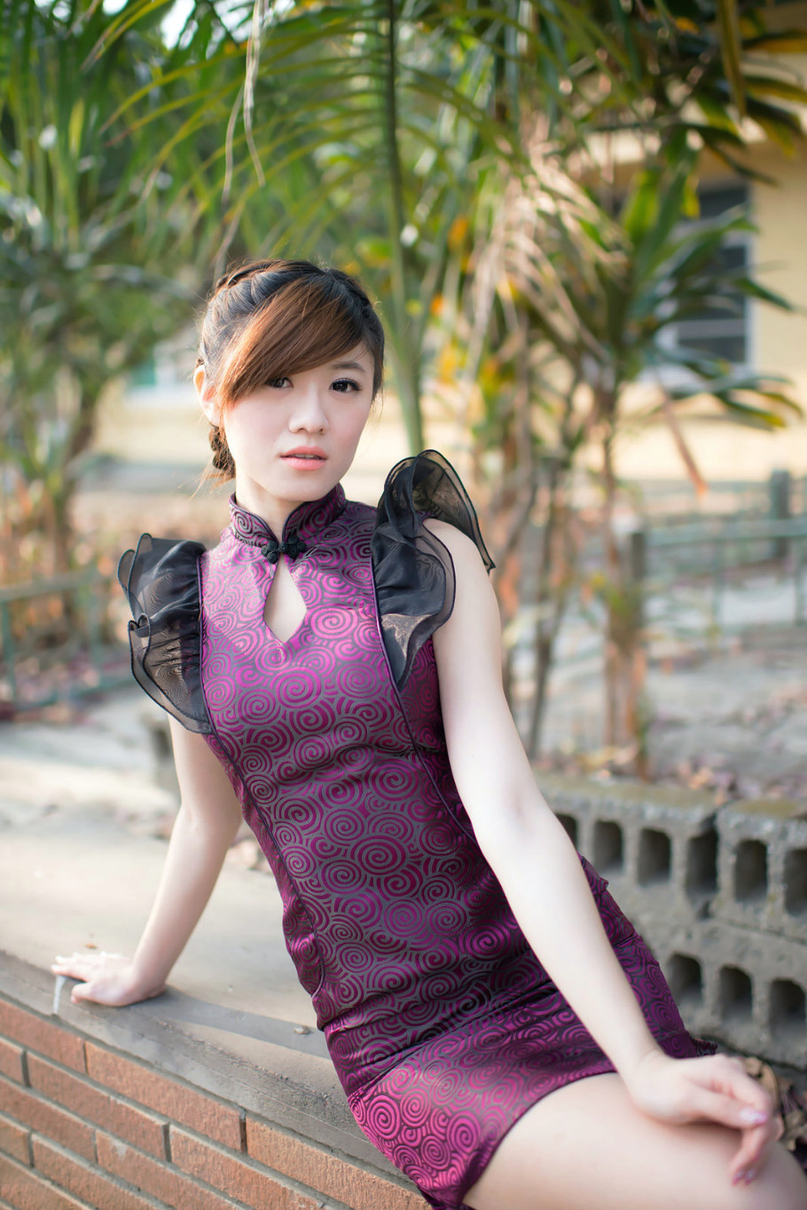 一个在户外阳光美景下的靓丽旗袍女子