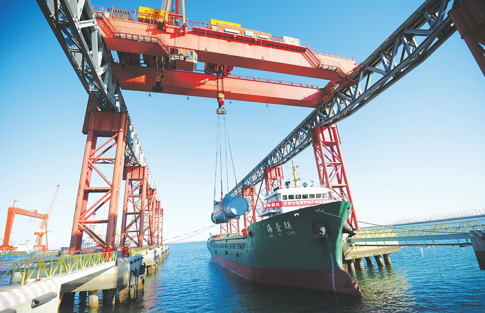 月25日,太重(天津)滨海重件码头重件班轮工作人员正在将重型货物装船