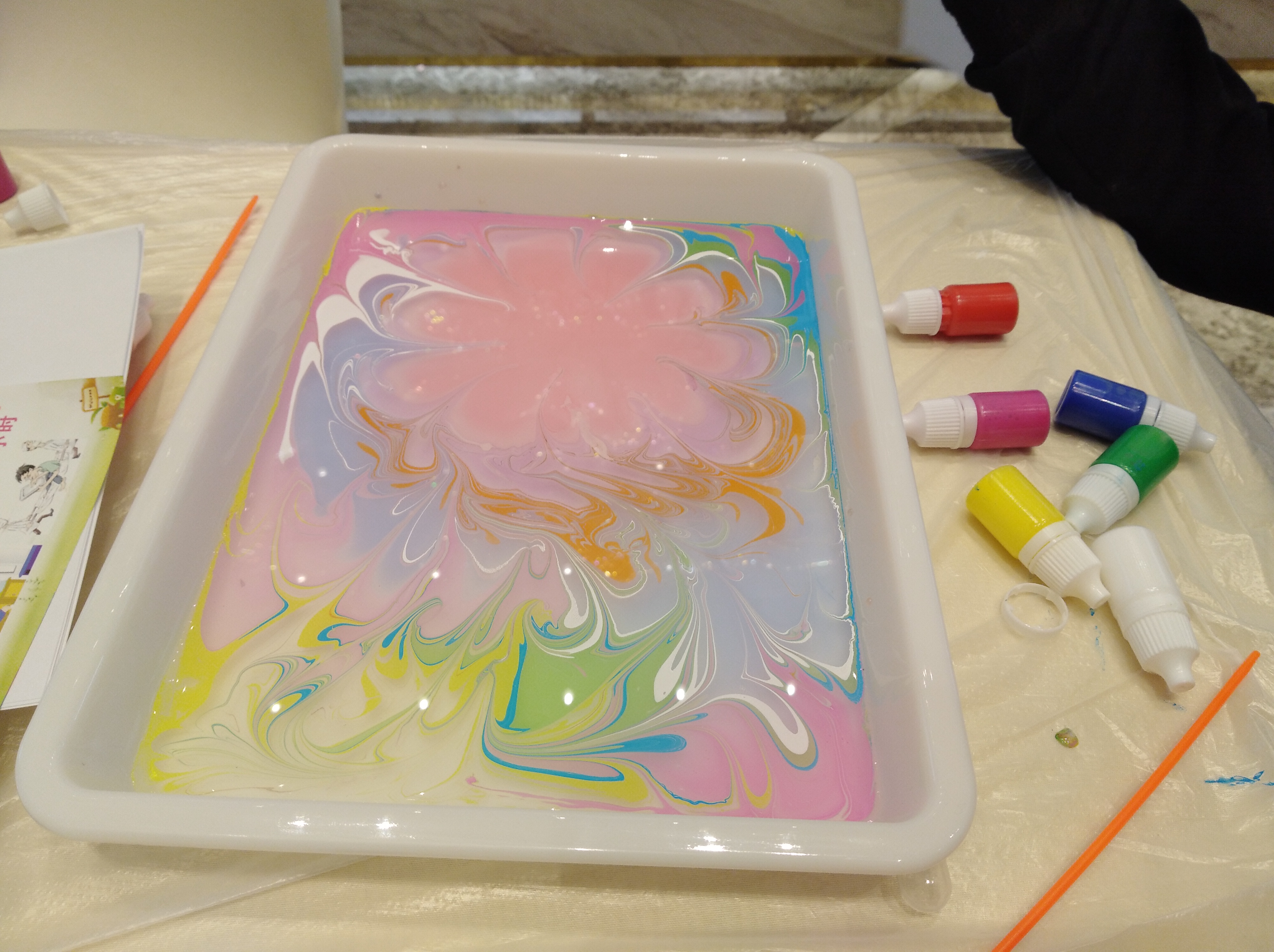 颜料,等待1分钟,然后再将纸慢慢抽离水面,"水中画"就被拓印到了纸上