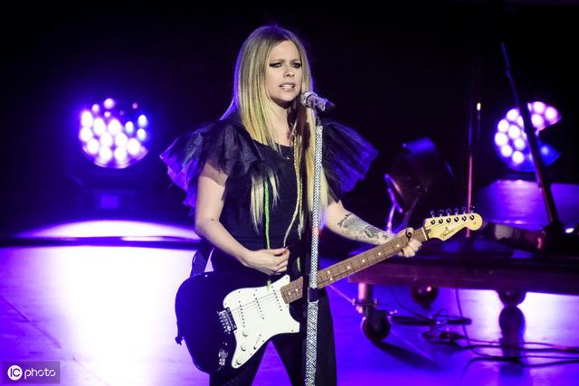 加拿大歌手艾薇儿穿黑色皮裤背着吉他现身演奏,摇滚朋克范儿十足