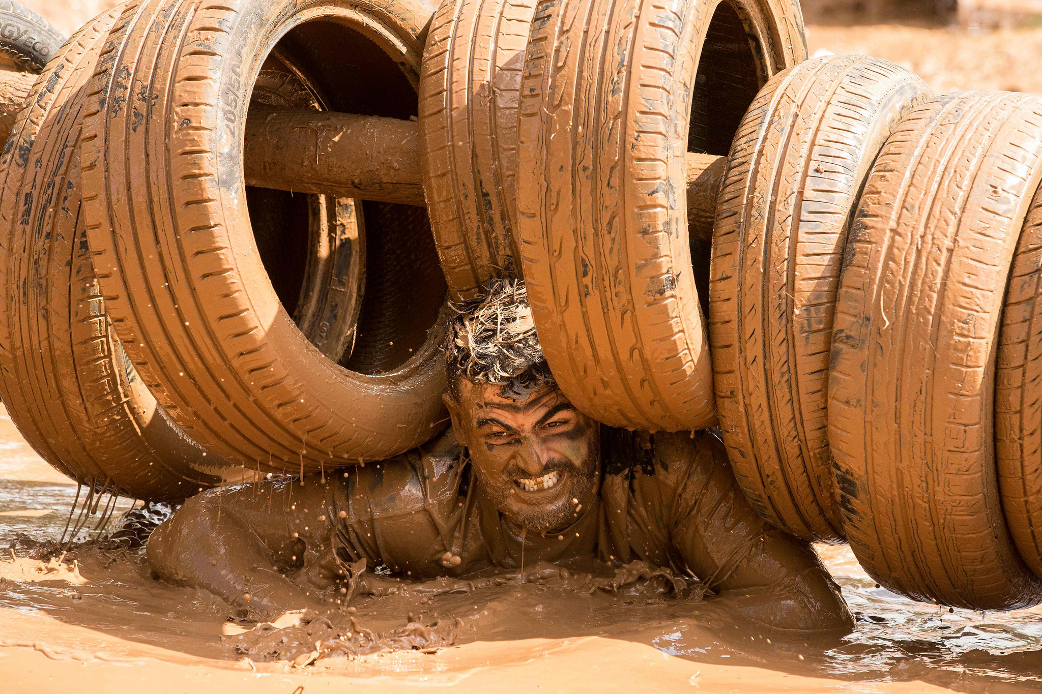 以色列举办13公里泥地跑 选手泥浆中奋力前行