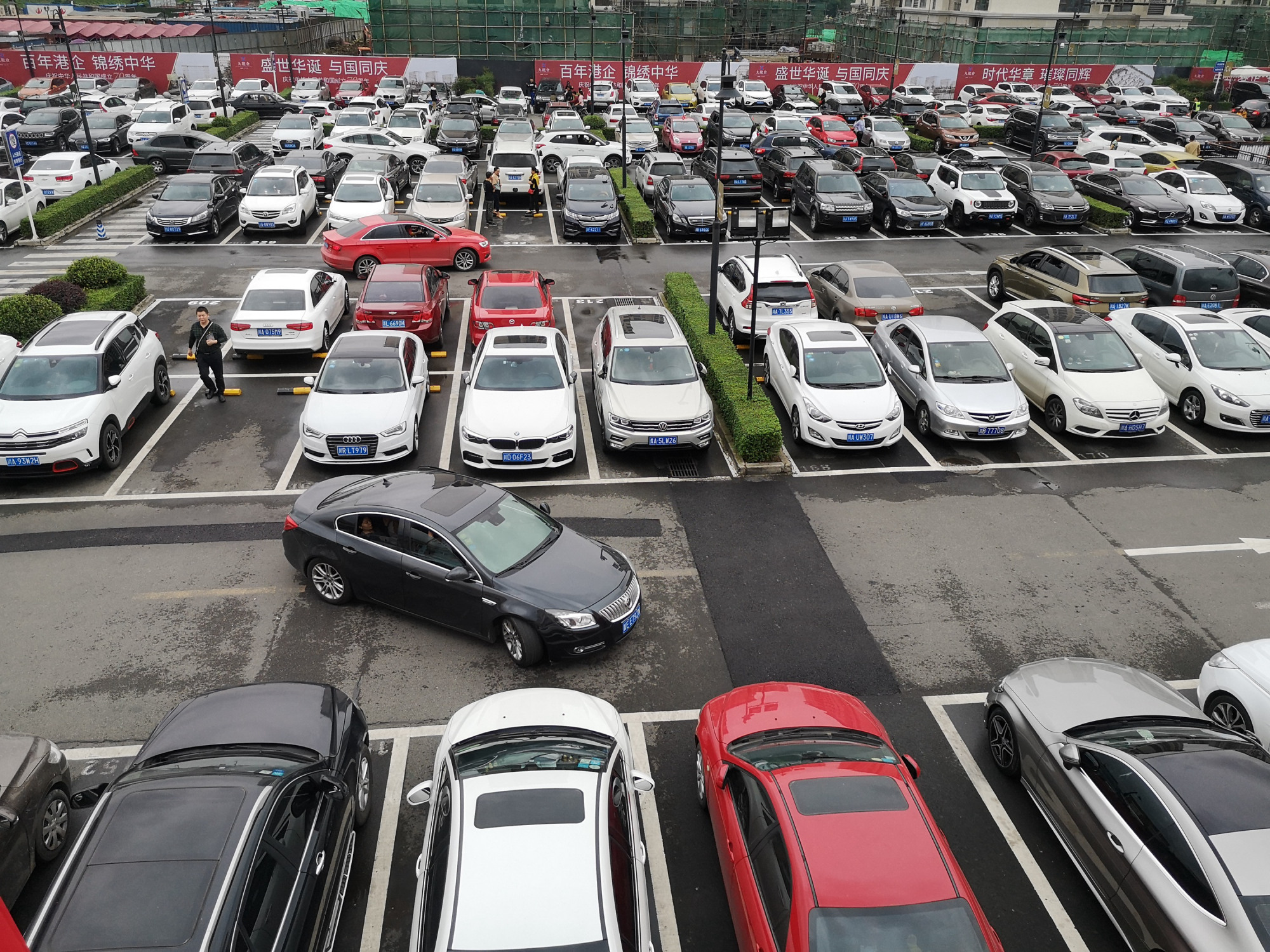 国庆长假间的大型露天停车场:被万辆私家车挤爆一位难求