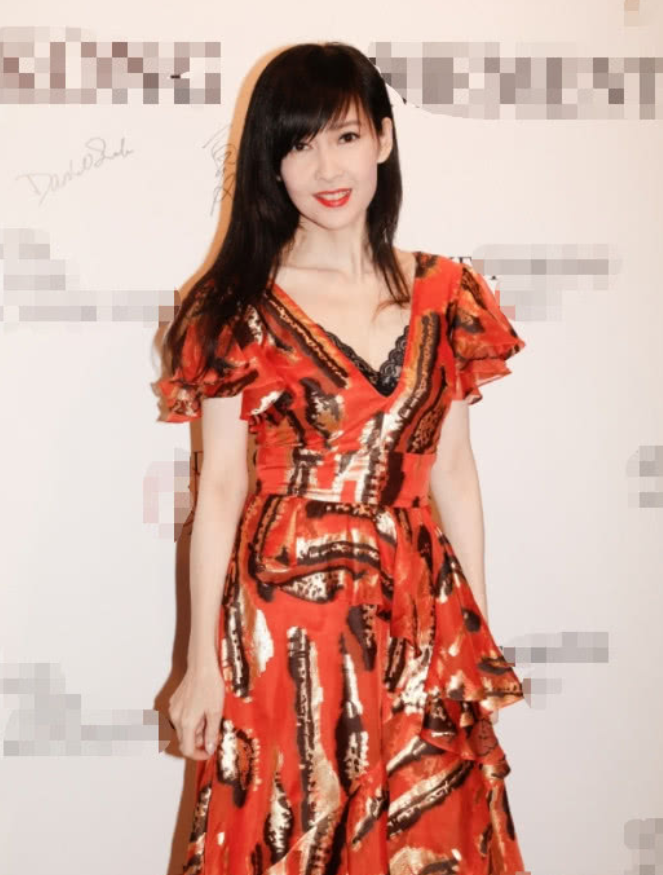 51岁周慧敏近照曝光,穿着橙红长裙出席活动,面对镜头依旧自信