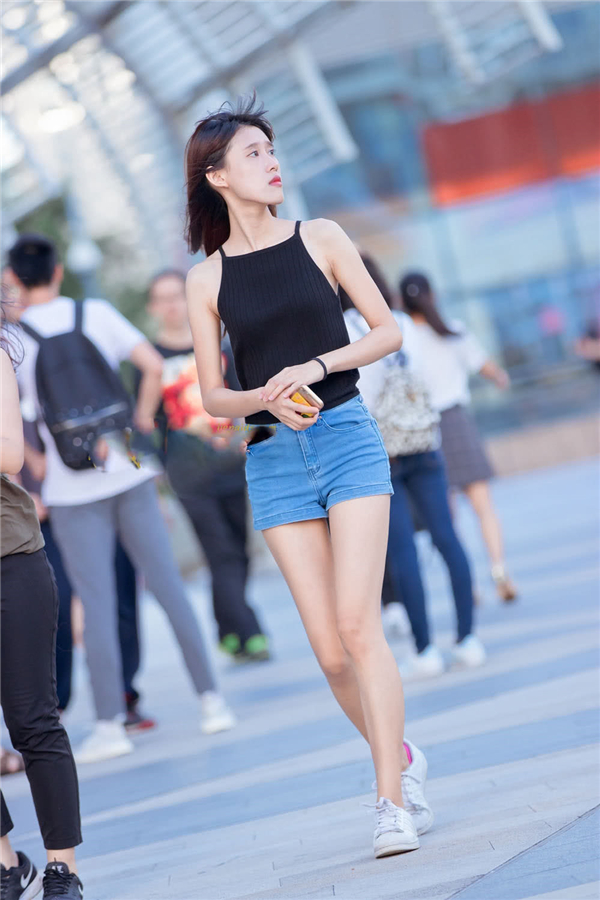 穿着黑色小吊带的妹子,配上牛仔热裤,非常时尚好看.