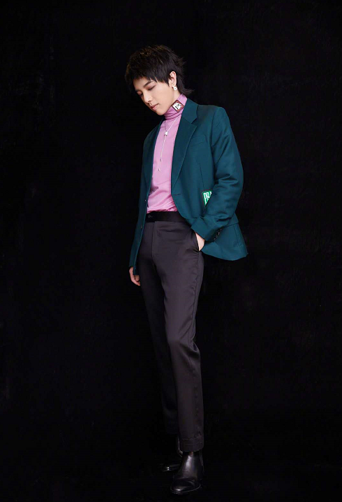 华晨宇穿着别出心裁,粉色衣服搭绿色西装,一只手插兜很帅气