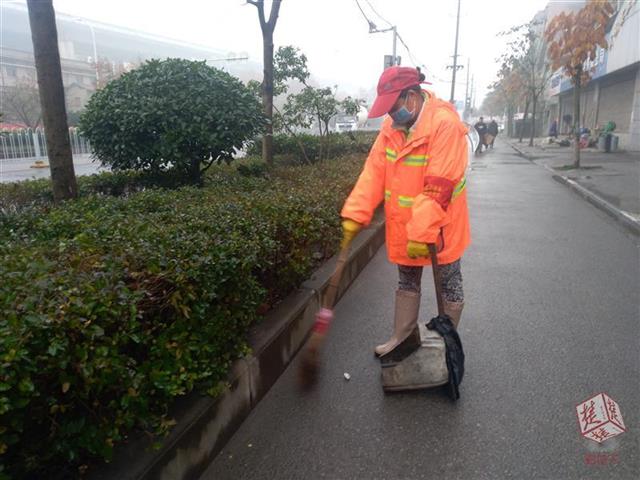 一张环卫工雨中牵引盲人夫妇过马路的背影照片