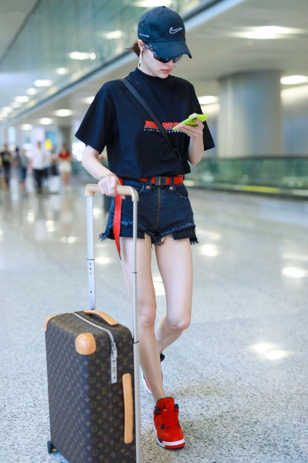 钟楚曦穿黑色字母t配黑色牛仔短裤现身 自推行李行走间星范十足