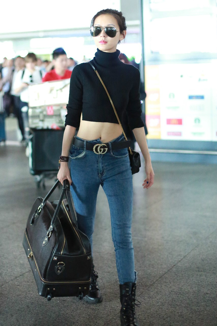 张予曦戴墨镜穿黑色毛衣搭配蓝色牛仔裤现身机场,扎丸子头好可爱