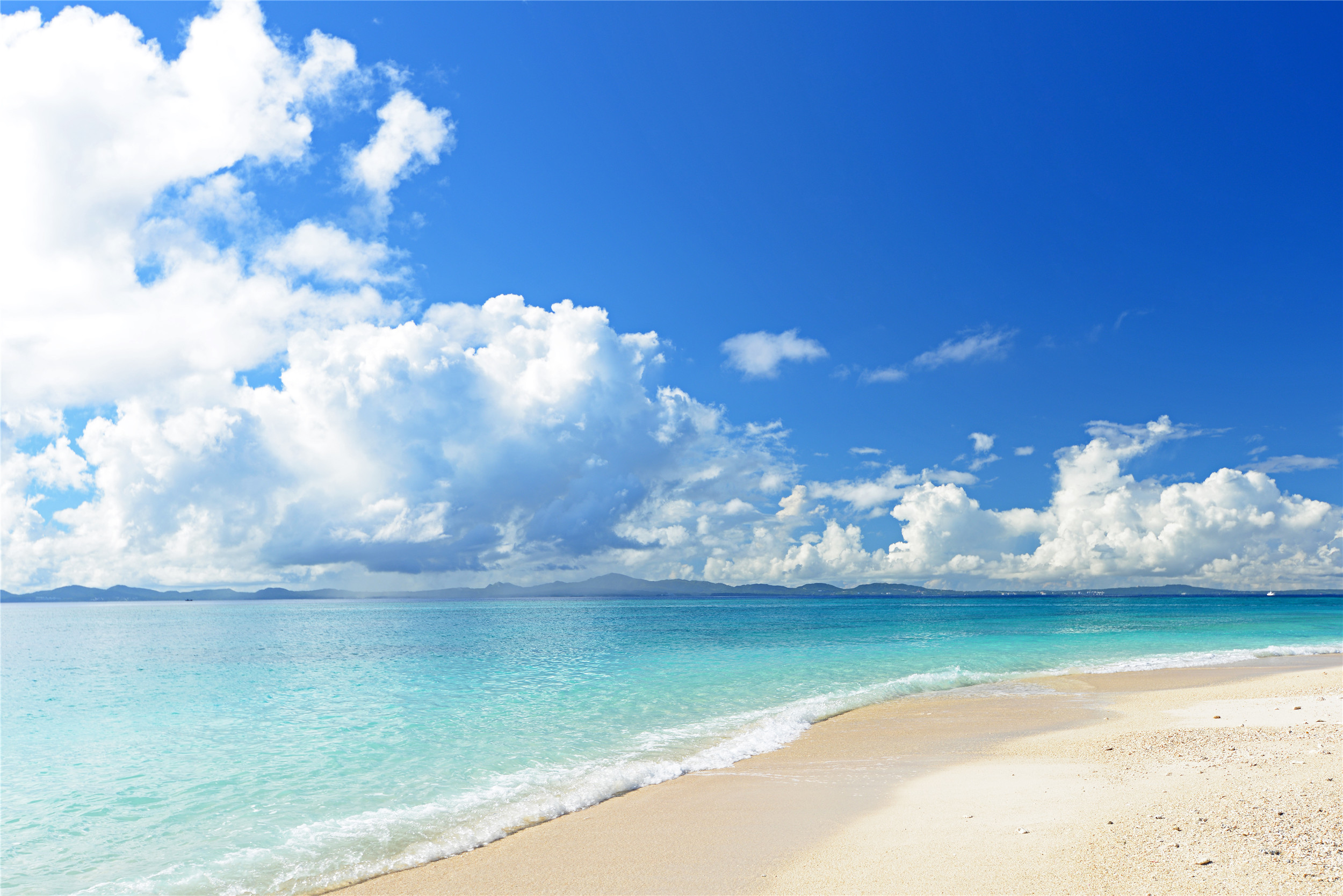 海滩的气魄和神韵:海水的淡蓝,金色的沙滩,飘在天空