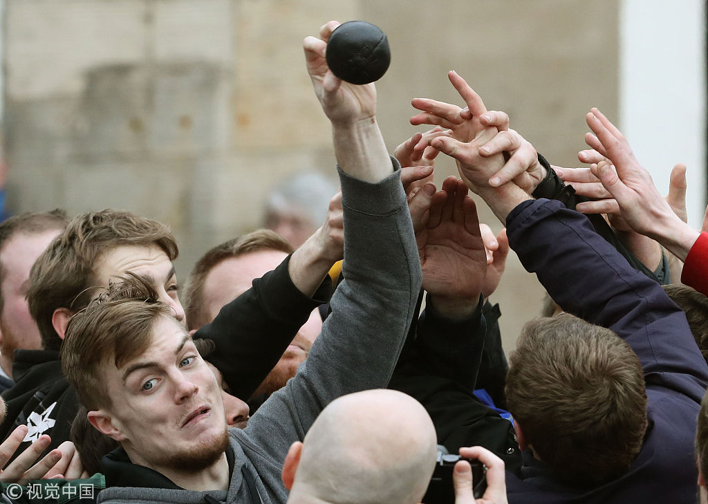 英国小城上演皮球争夺战 ,众人奋力争抢到脸"变形"