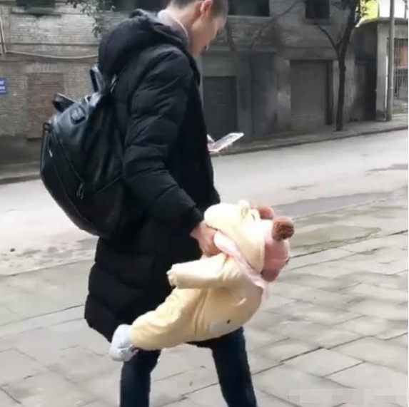 奶爸带宝宝逛街,一只手提着宝宝,一只手玩手机,宝宝是捡来的?