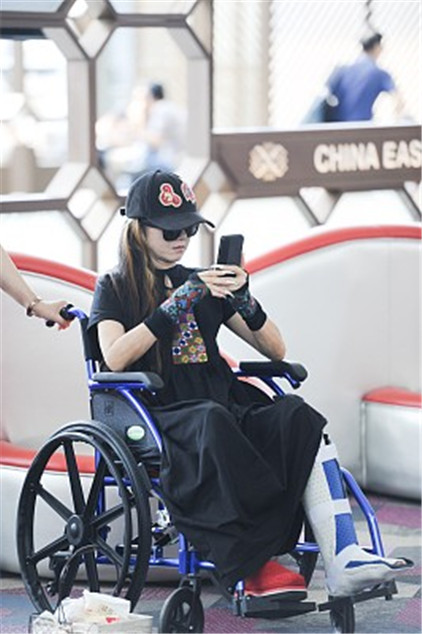 杨丽萍坐轮椅亮相机场,骨折不影响好心情,依然保持完美的微笑