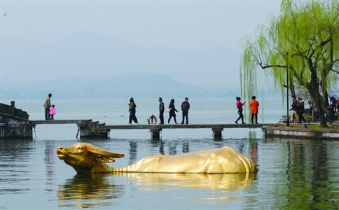 美图摄影:傍晚,西湖边金牛出水,引的游客纷纷驻足观看