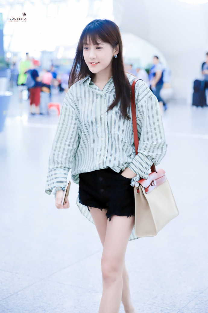 李艺彤穿条纹衬衫搭配黑色牛仔短裤现身机场,腿又白又细十分吸睛