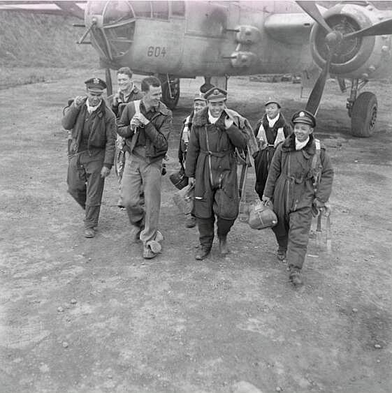 1945年珍贵老照片:小伙扛着炮弹一脸愉悦,美国飞行员斗黑熊玩耍