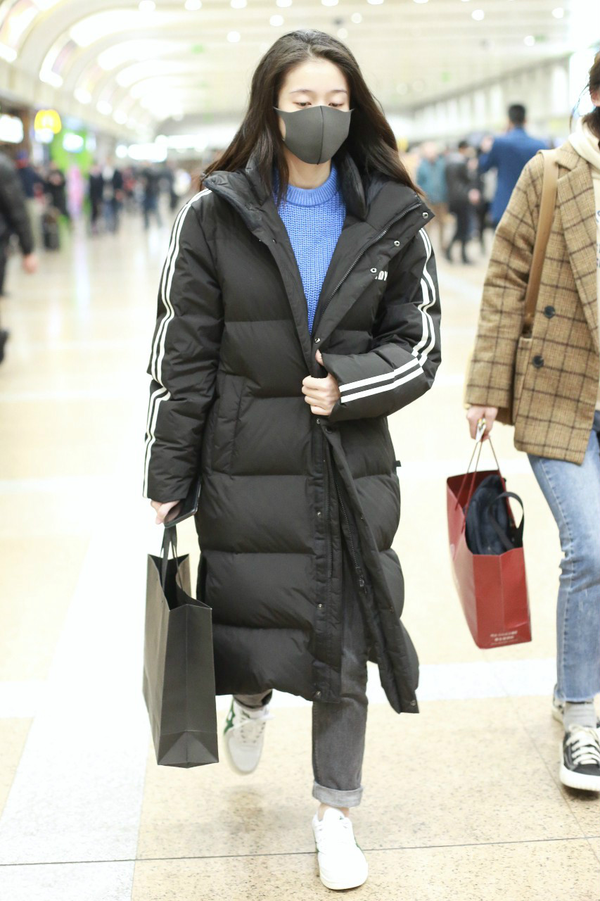 张雪迎戴黑色口罩穿黑色长款羽绒服现身机场,穿着非常保暖又时尚