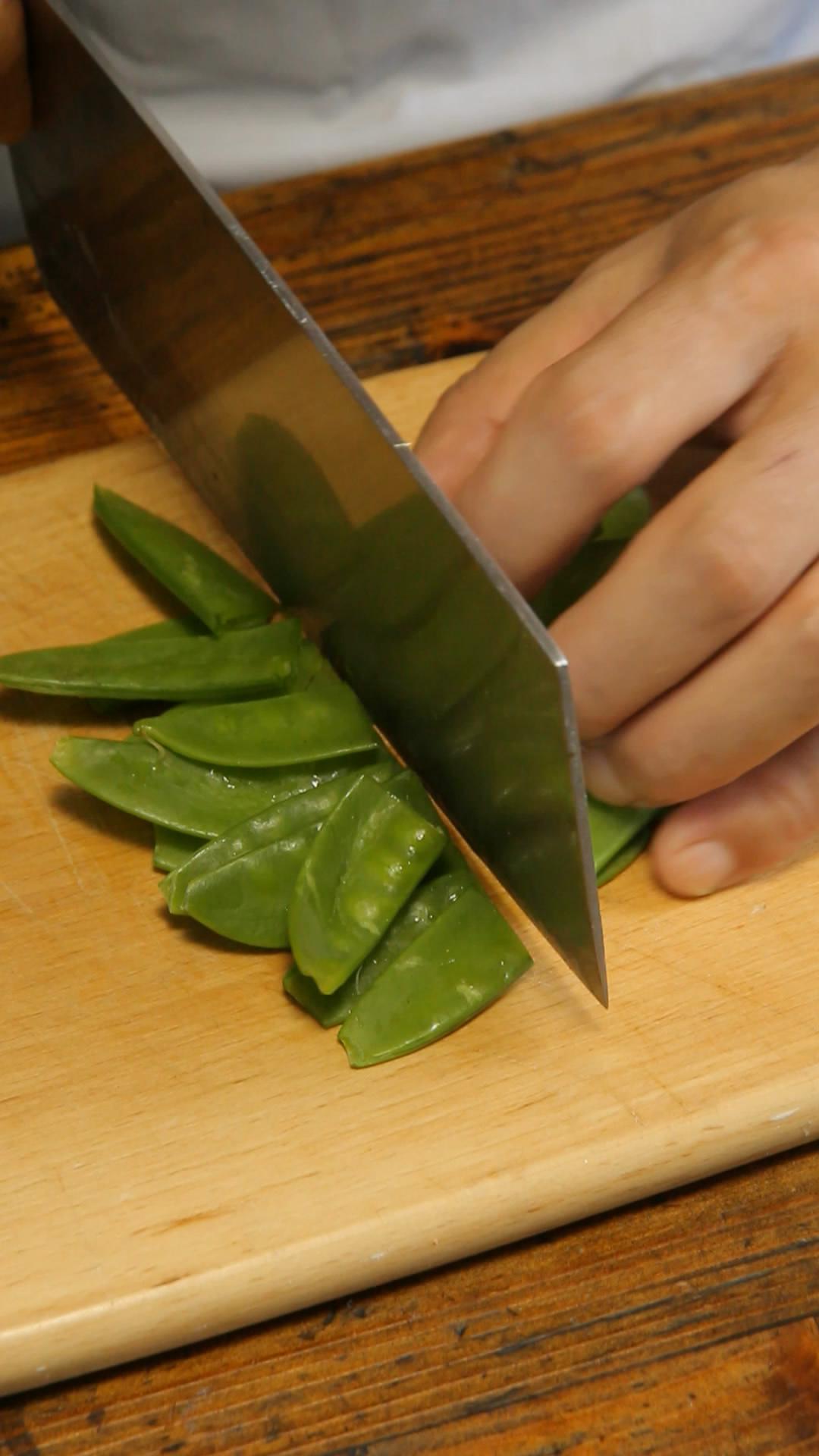 荷兰豆 2,食材改刀,将荷兰豆切成两半,胡萝卜切片,大虾去头,去虾线