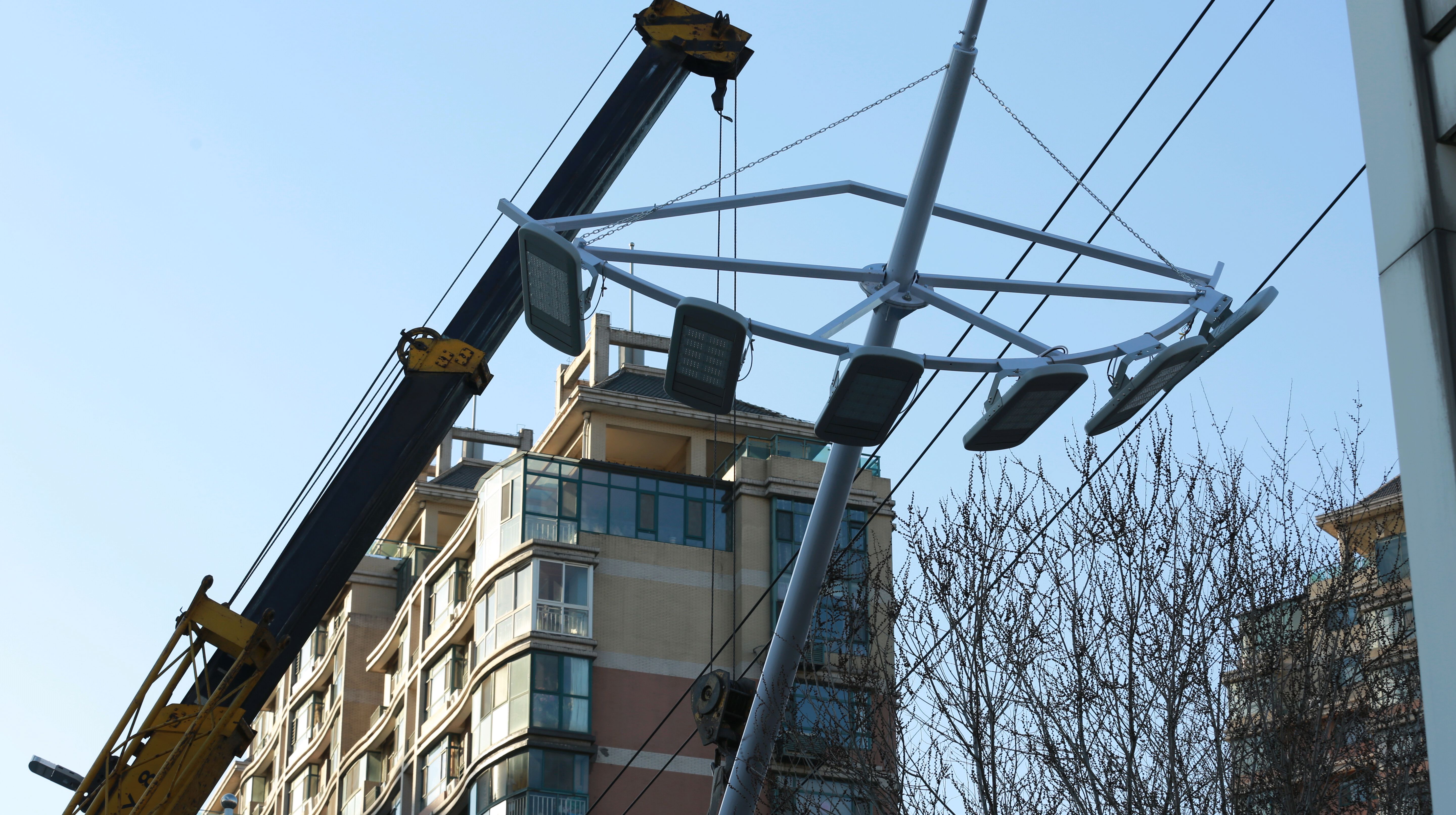 3月12日下午,施工人员正在潍坊市民生街白浪河桥西侧安装照明设施时的