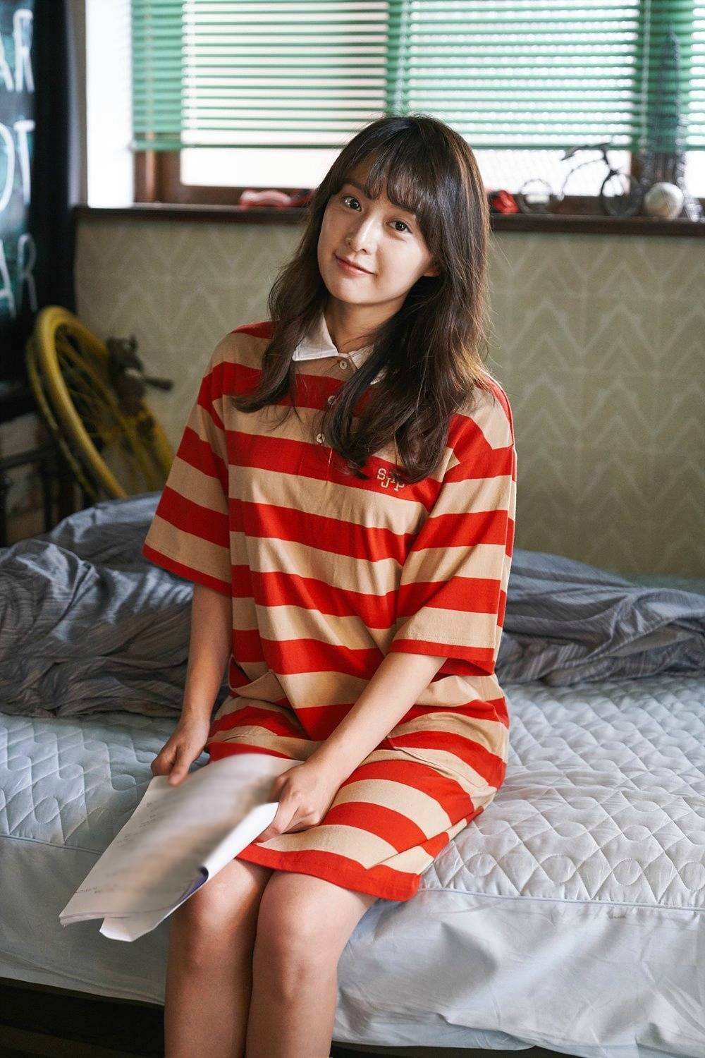 这张照片中的金智媛是一头利落的短发,戴着精致的耳饰,上身选择一个