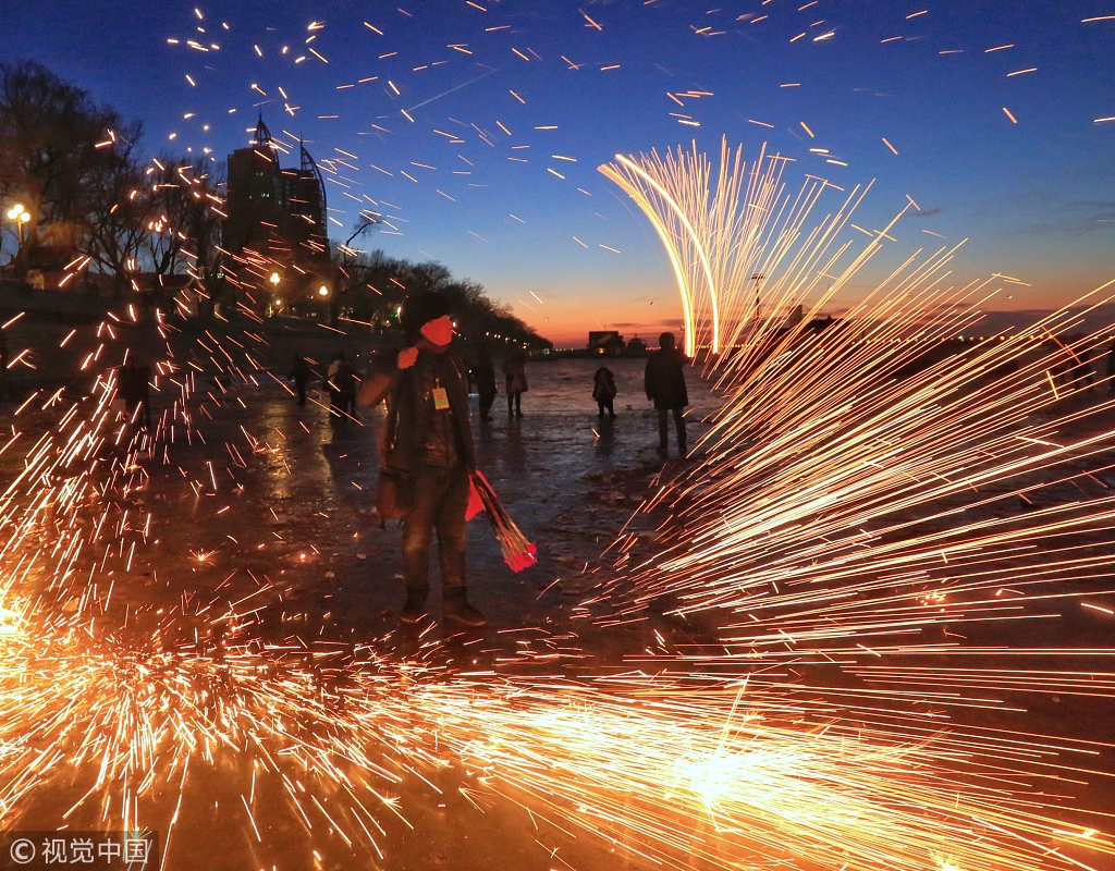 哈尔滨:松花江上游客玩手甩烟花 场面壮观