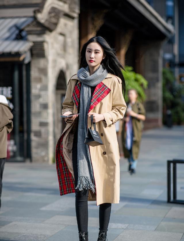 棕色的长款风衣搭配围巾,紧身的休闲裤显得整体线条非常的流畅,秀出