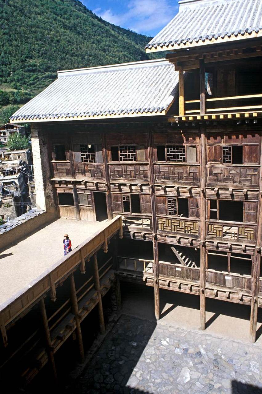 春天的布依族建筑被新绿和绚丽的花朵点缀,呈现出