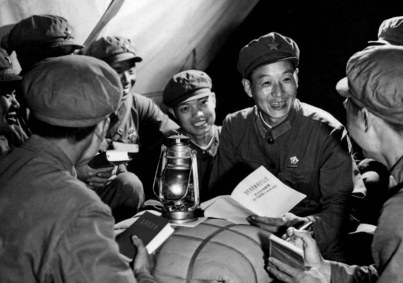 解放军同志和当地的女同志们一起洗衣服,脸上笑容饱满,气氛和谐友爱.